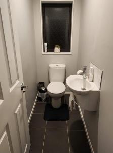 a bathroom with a toilet and a sink and a window at A room in Riverstone Terraces with views - Homestay in Upper Hutt