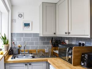 a kitchen with white cabinets and a sink at The Nook in Bishop Auckland