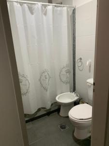 Un baño con inodoro y cortina de ducha. en VILLAGE APART, en Villa María 14 fotos más