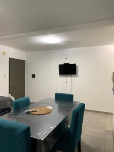 Un comedor con una mesa y sillas azules. en VILLAGE APART, en Villa María