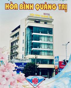 a poster for a hotel in front of a building at Khách sạn HOÀ BÌNH QUẢNG TRỊ in Ðông Hà