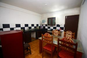 a kitchen with a table and chairs in a room at Mount view Holidays in Vagamon