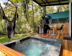 a swimming pool in a backyard with a hammock at ChicoRico Studios in Uvita