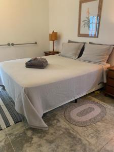 a large bed with a white blanket on top of it at Quarto Varanda - Residência Gaia Itatiaia in Itatiaia