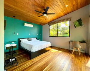 1 dormitorio con 1 cama y ventilador de techo en ChicoRico Studios, en Uvita