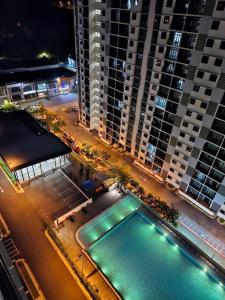 - une piscine en face d'un grand bâtiment la nuit dans l'établissement Homestay In Desaru, à Bandar Penawar