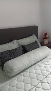 - un lit avec une couette et des oreillers blancs dans l'établissement Homestay In Desaru, à Bandar Penawar