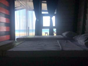 twee bedden in een kamer met een raam bij Camp Soteria Resort in San Agustin