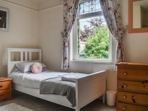 een slaapkamer met een bed en een raam bij Oakleigh in Rathmell