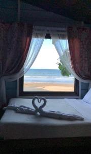 a heart on a bed in front of a window at Camp Soteria Resort in San Agustin