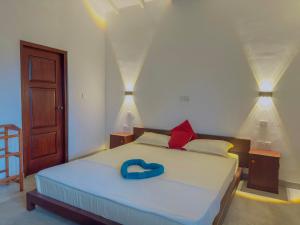 a bedroom with a bed with a blue ring on it at Sayuru Villa in Hikkaduwa