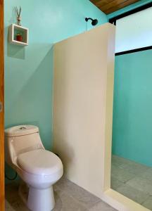 a bathroom with a white toilet in a room at ChicoRico Studios in Uvita