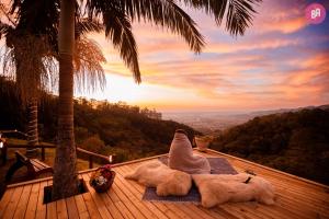 a person laying on a deck with a view of a mountain at Pousada Caminho dos Canyons in Praia Grande