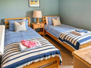 1 dormitorio con 2 camas y mesa en Grey Croft, en Christon Bank