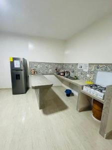 a kitchen with a refrigerator and a counter top at Casa de Huéspedes Playas Arena in Playas