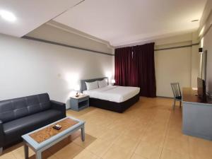 Postel nebo postele na pokoji v ubytování Grace Hotel Lahad Datu