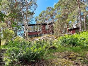 uma casa no topo de uma colina com árvores em Holiday home VÄRMDÖ VI em Djurhamn