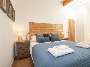 a bedroom with a blue bed with two towels on it at 4 Water's Edge in Looe
