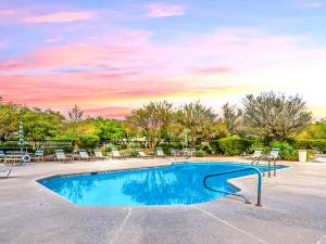 uma piscina com cadeiras e um pôr-do-sol em Luxury 3BD/2BA Home Near Tucson w/ Desert Views em Oro Valley