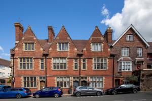 un gran edificio de ladrillo con coches estacionados frente a él en Number 42, en Arundel