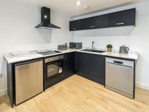 una cocina con electrodomésticos de acero inoxidable y negro en No,10 Apartments, en Blackpool