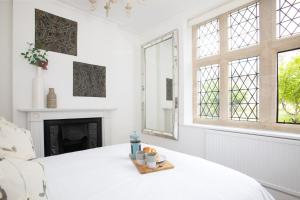 a white room with a bed and a fireplace at Number 42 in Arundel