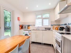eine Küche mit weißen Schränken und einem Holztisch in der Unterkunft Honey Hanger - W43106 in Bradworthy