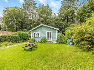 ein grünes Haus mit einem Picknicktisch im Hof in der Unterkunft Honey Hanger - W43106 in Bradworthy