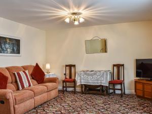 The Old Byre في Haswell: غرفة معيشة مع أريكة وطاولة