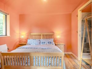 um quarto com paredes cor de laranja e uma cama com almofadas azuis em Zambezi - Uk44827 em Holton