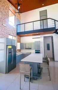uma cozinha com um frigorífico, uma mesa e cadeiras em Hector House em Uvita