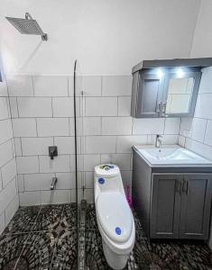 a bathroom with a toilet and a sink at Hector House in Uvita