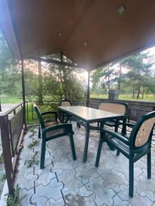 un patio con mesa y sillas en un porche en Коттедж на берегу оз. Севан, en Sevan