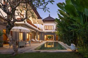 una casa con piscina en el patio en Desa Swan Villas & SPA, Keramas en Keramas