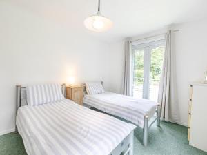two beds in a room with a window at Hollies - W43107 in Bradworthy