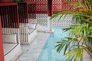 a swimming pool with two benches and a red fence at Talakkia Boutique Hotel in Bangkok