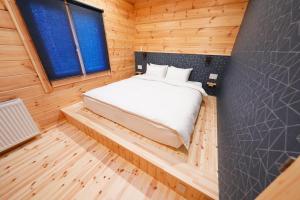 una camera da letto in una baita di tronchi con un letto in esso di Forrest Kitakaruizawa a Tsumagoi