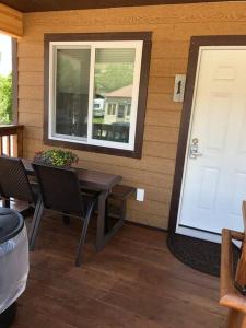 eine Veranda mit einem Tisch, einem Fenster und einer Tür in der Unterkunft ParkWay Yellowstone Guest House Room #1 in Gardiner