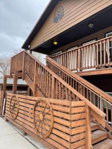 ein Haus mit einer großen Holzterrasse mit einem Holzrad in der Unterkunft ParkWay Yellowstone Guest House Room #1 in Gardiner