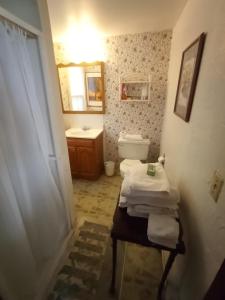 y baño con lavabo, aseo y espejo. en Sea Breeze Inn beach rentals en Barnstable