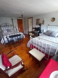 1 dormitorio con 1 cama, mesa y sillas en Sea Breeze Inn beach rentals, en Barnstable