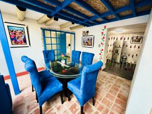 une salle à manger avec des chaises bleues et une table en verre dans l'établissement AITANA'S HOUSE - SAN BLAs, à Cusco