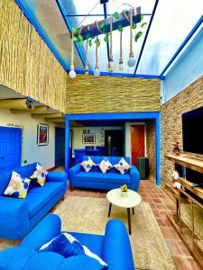 a living room with blue couches and a tv at AITANA'S HOUSE - SAN BLAs in Cusco