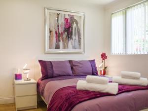 ラネリーにあるWaun Bungalowのベッドルーム1室(紫色のベッド1台、タオル2枚付)