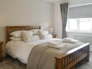 a bedroom with a large bed with pillows and a window at Rydal Cottage in Keswick