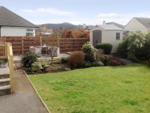 a backyard with a fence and a yard with green grass at Rydal Cottage in Keswick