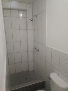 a white bathroom with a shower and a toilet at Hospedaje Vivanco 