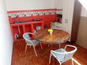 a dining room with a table and chairs and a kitchen at Hospedaje Vivanco 
