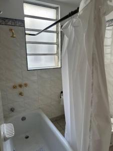 a bathroom with a white tub and a shower curtain at Santa Fe Apart in Buenos Aires