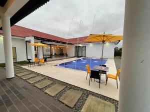 un patio con mesa, sillas y piscina en Acacias, Meta, Casa Arauco, en Acacías